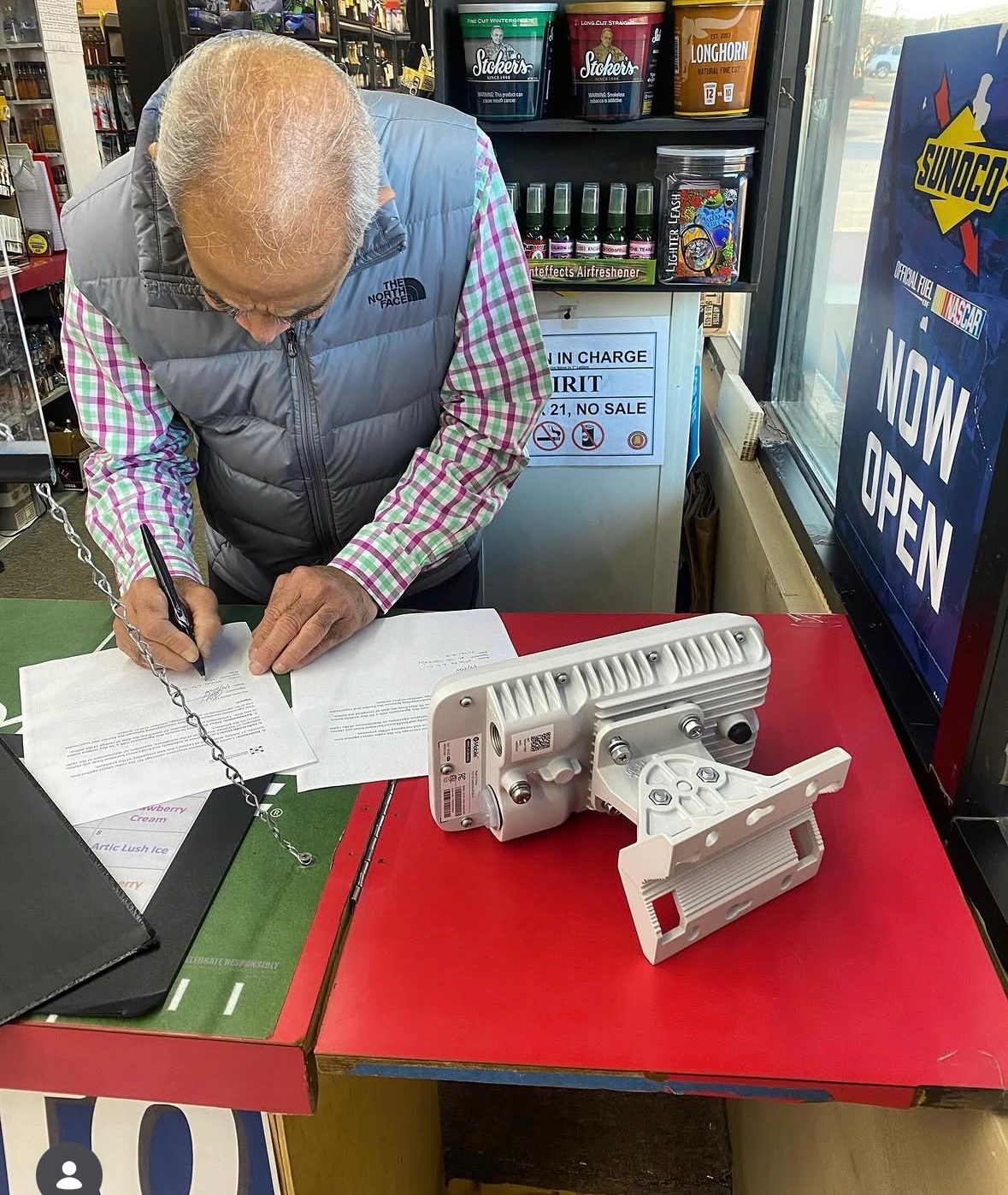 Venue representative signing an agreement beside wireless network equipment